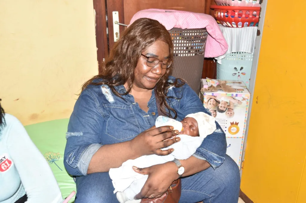 Céline donne le biberon à un nourrisson à l'orphelinat