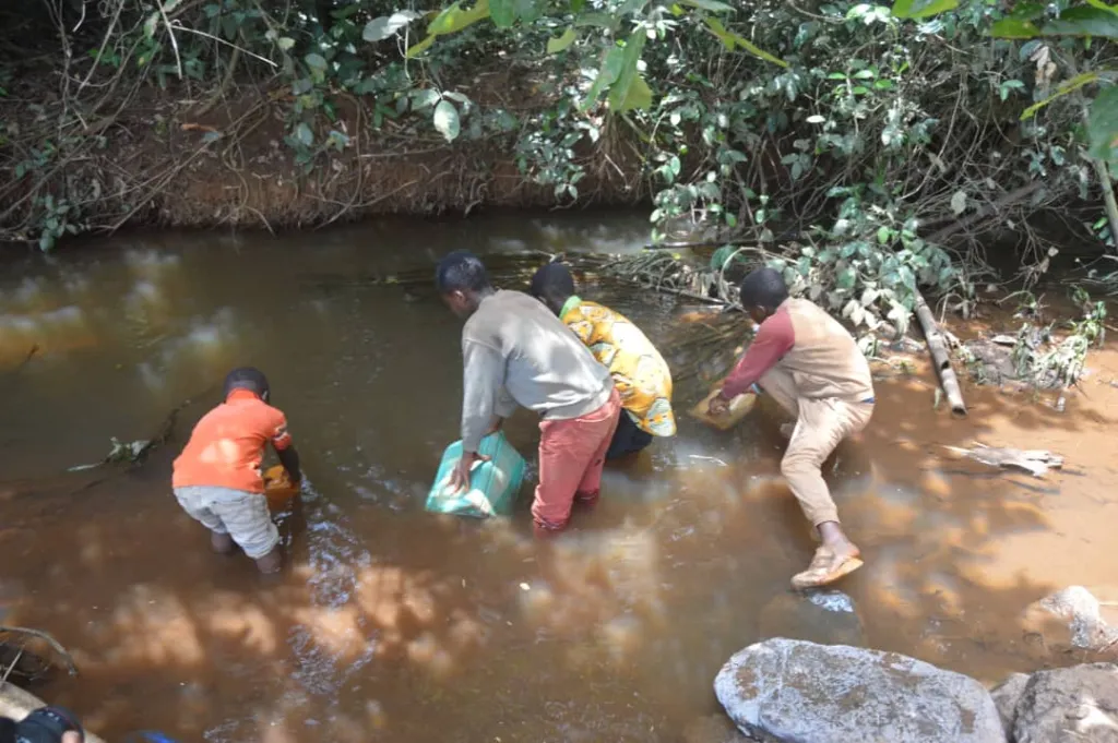 Des enfants puisent l'eau souillée à Bamougoum